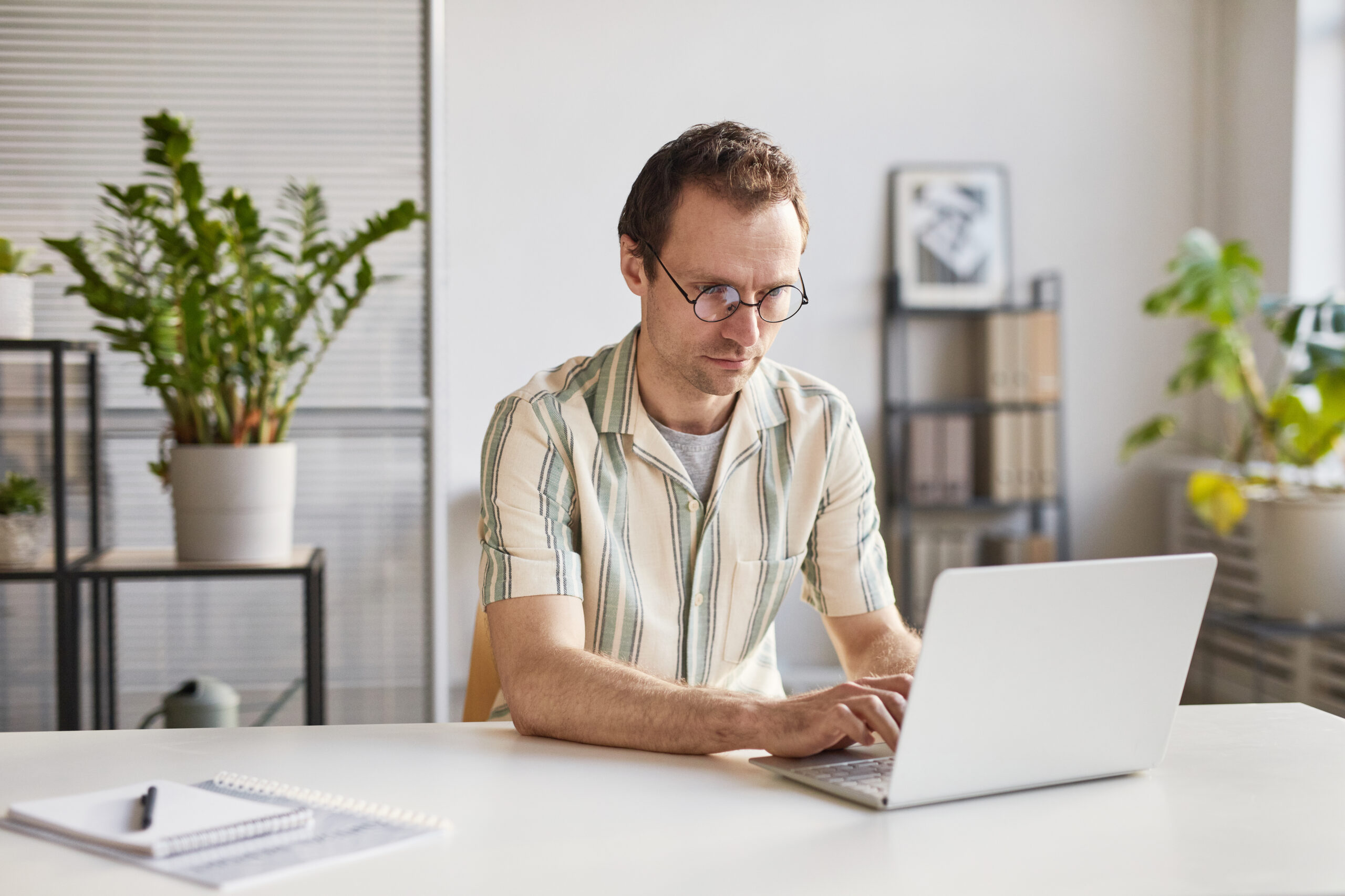 Homme travaillant devant un ordinateur portable dans son bureau