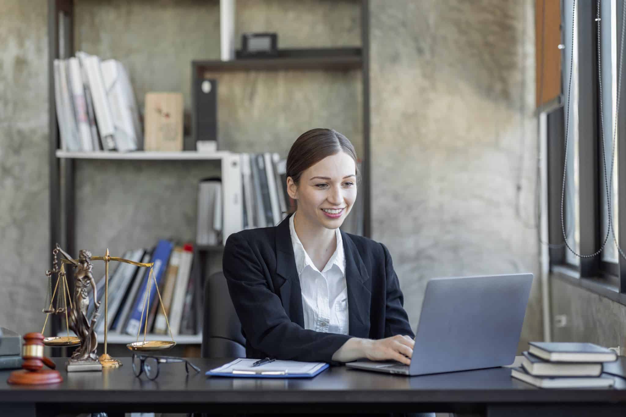 Photo d'une avocate, profession libérale, dans son bureau, devant un ordinateur