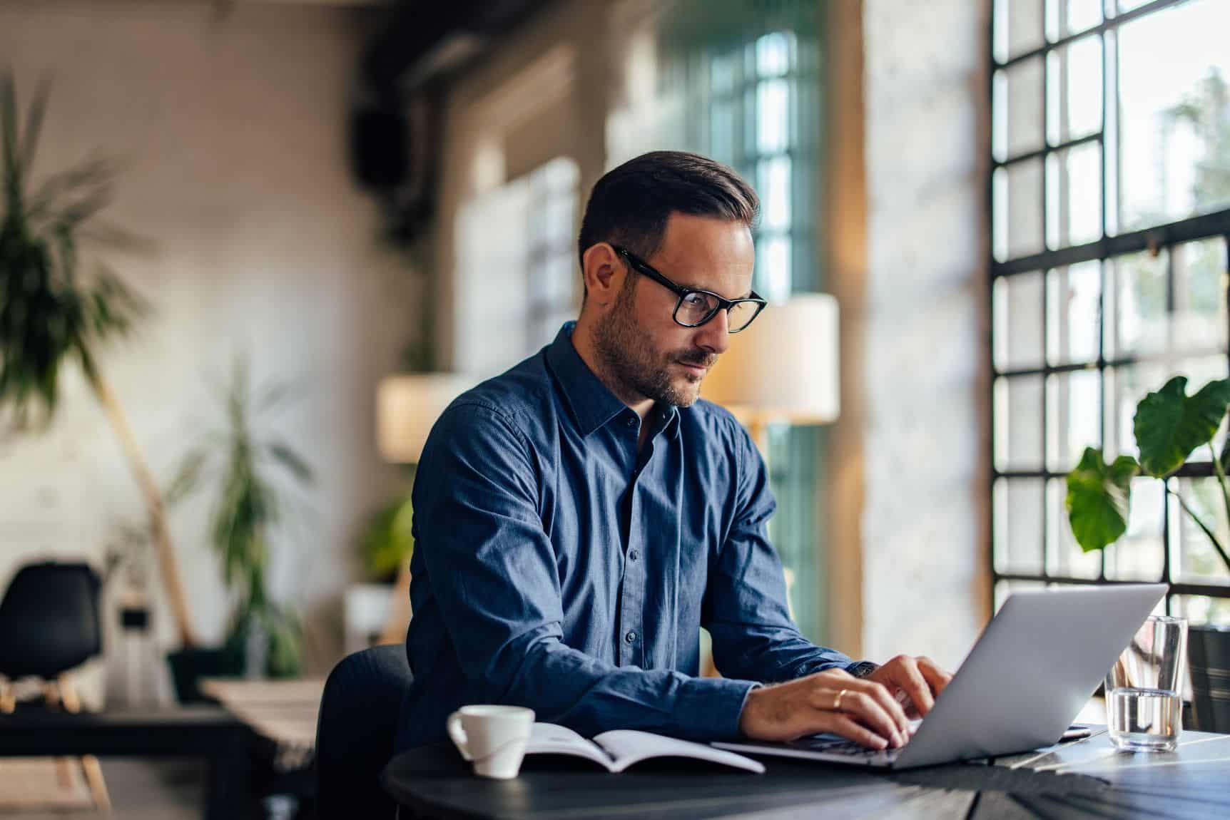 photo d'un homme devant son PC portable, il consulte les logiciels de facturation électronique gratuits