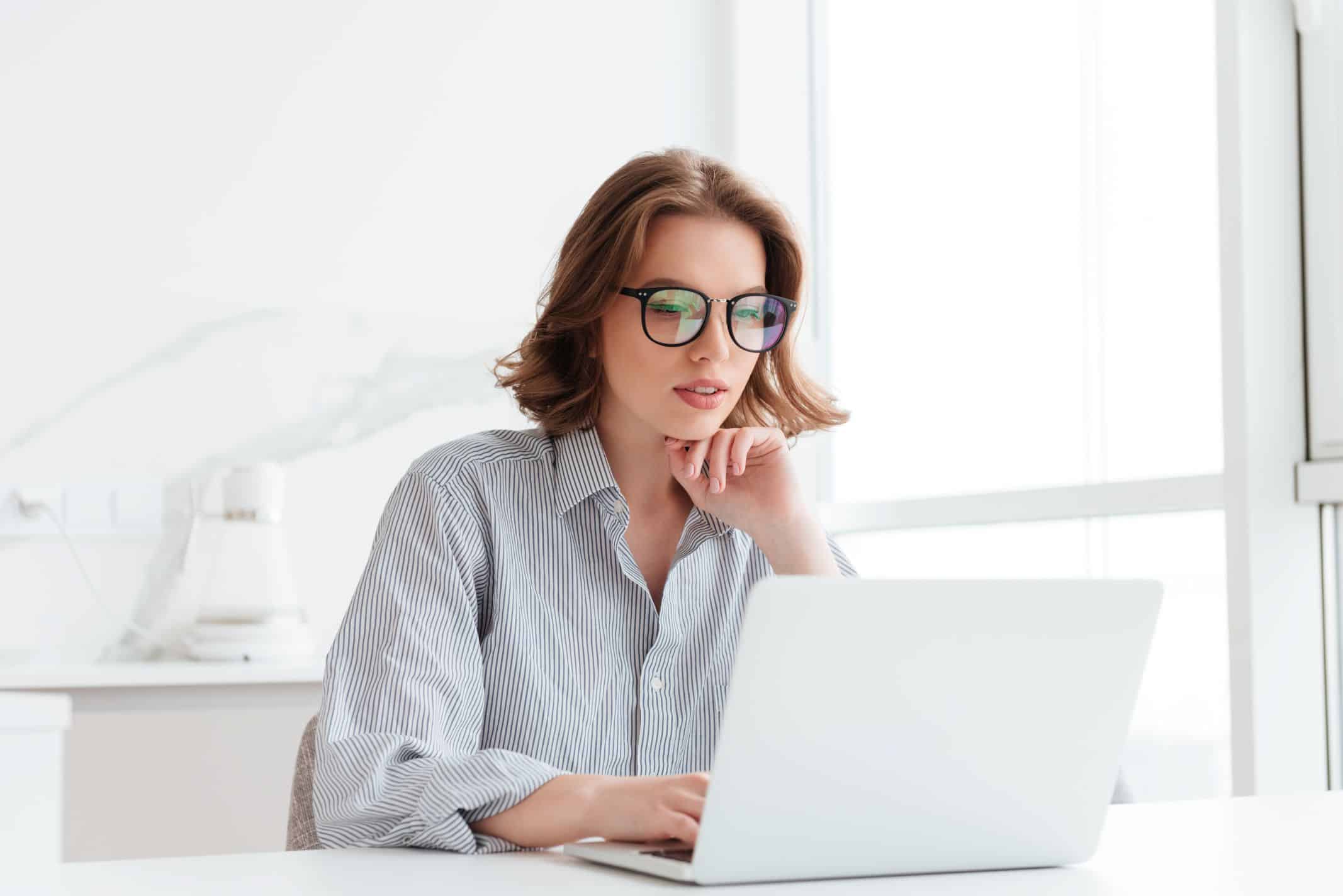 Personne travaillant sur son ordinateur portable sur l’archivage des factures électroniques, leurs obligations légales et leur durée de conservation.