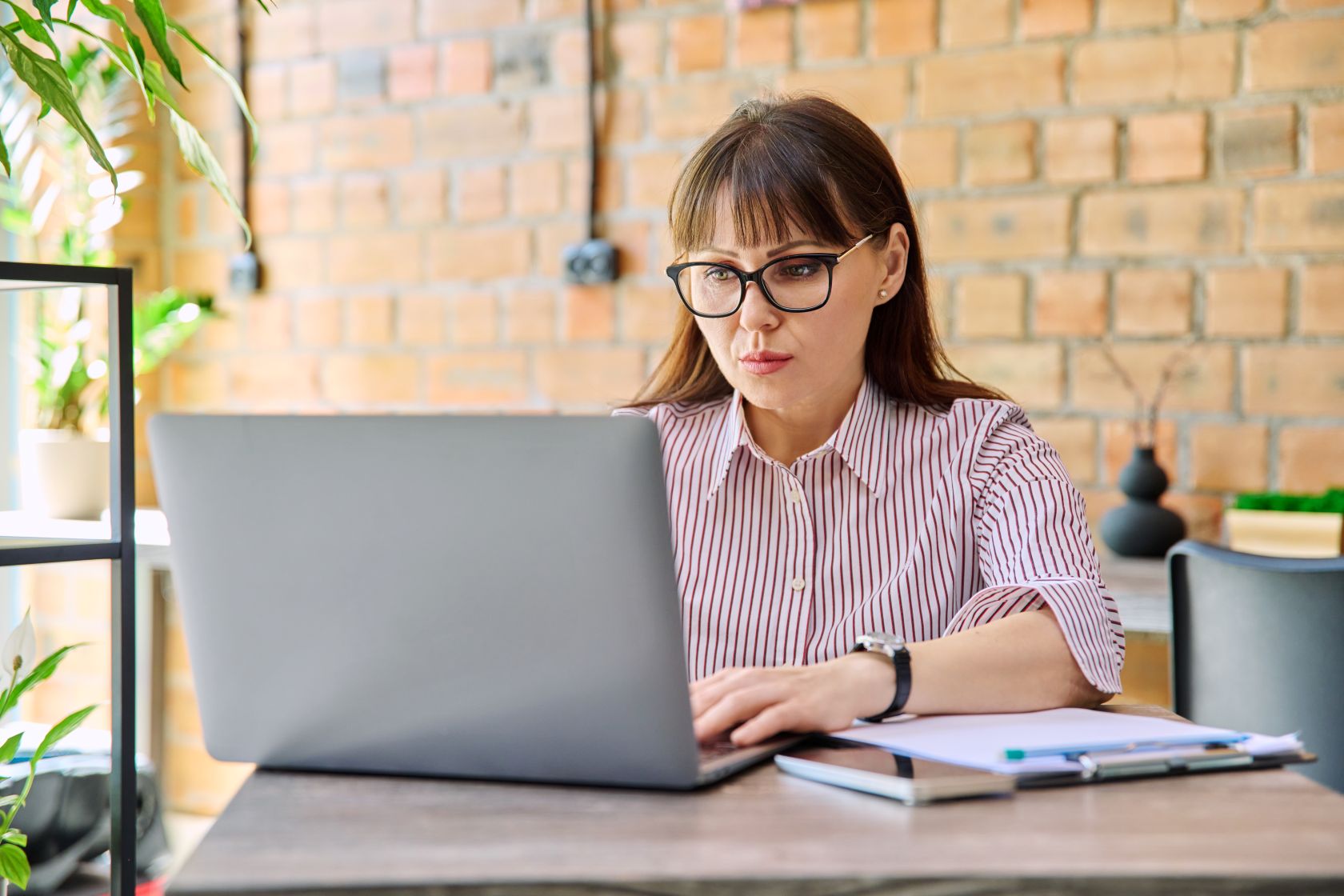 Photo d'une femme consultant un ordinateur pour s’informer sur le rôle, les obligations et le choix d'une Solution Compatible pour la facturation électronique.