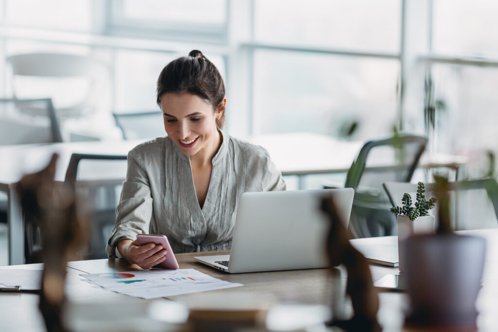 Photo d'une femme regardant son téléphone à son bureau